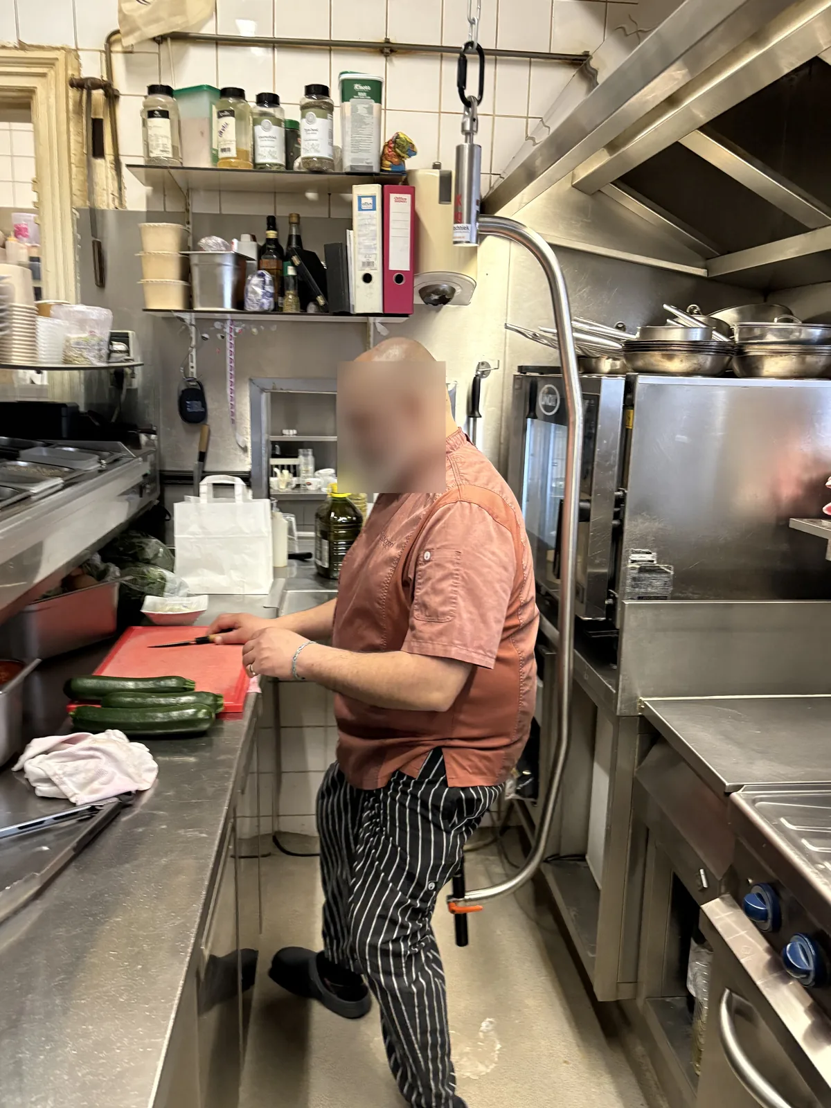 Kok snijdt aan de werktafel terwijl hij op het zadel van de mobiliteitsbeugel steunt