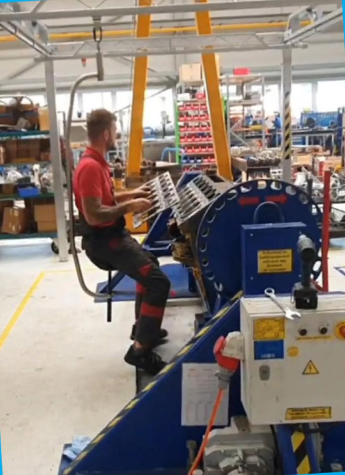 Monteur aan een machine in een productiehal, zittend ondersteund door de mobiliteitsbeugel