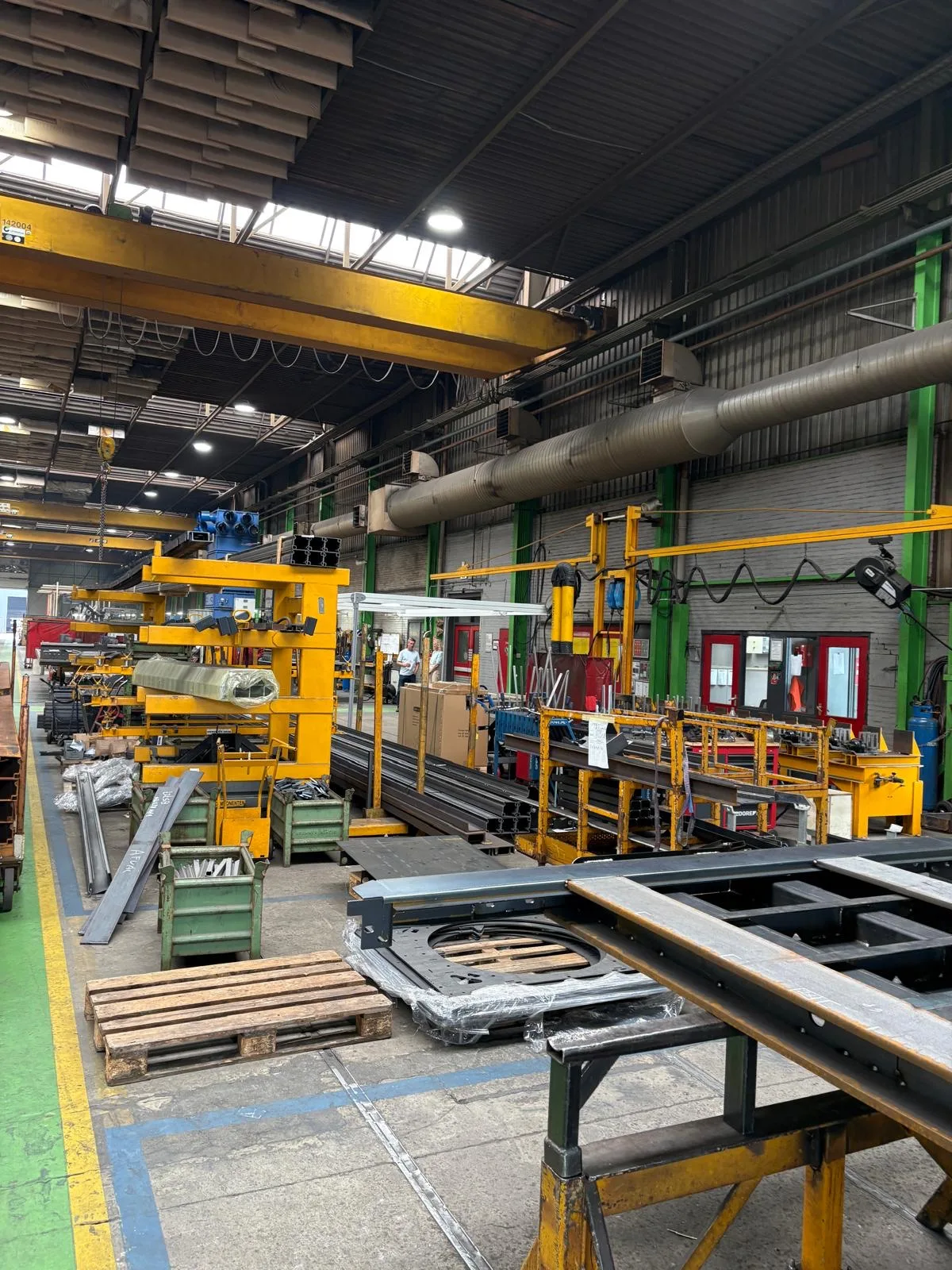 Productiehal met werkbanken en materiaal op stellingen